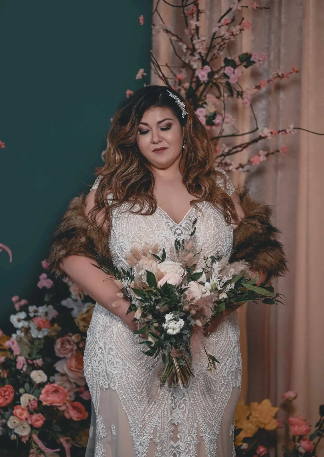 Bride in a long-sleeve gown in an emerald styled room