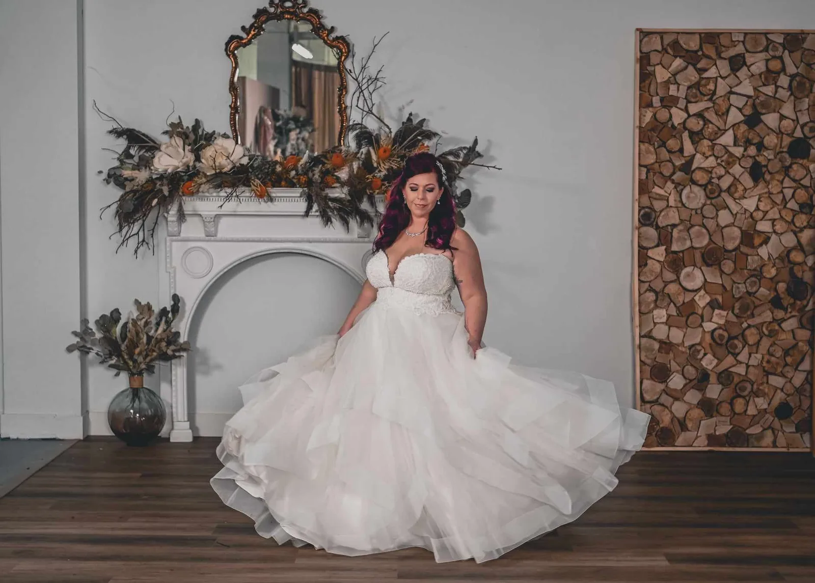 Bride beside an arched mirror in a white gown