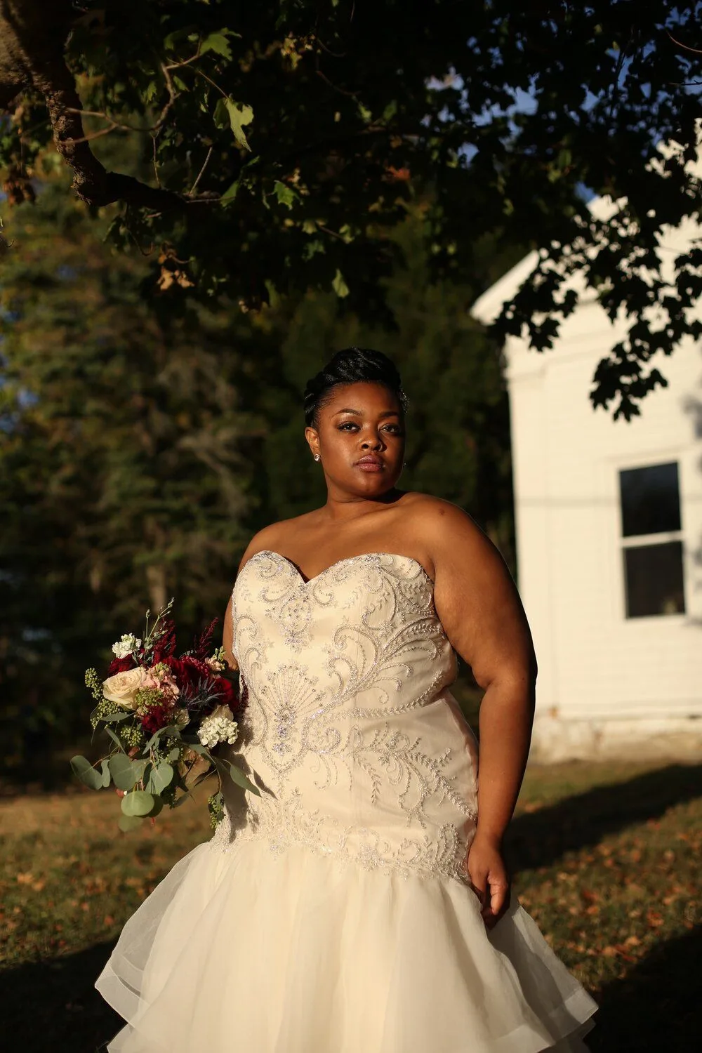 Bride outdoors beside a tree in a fitted gown