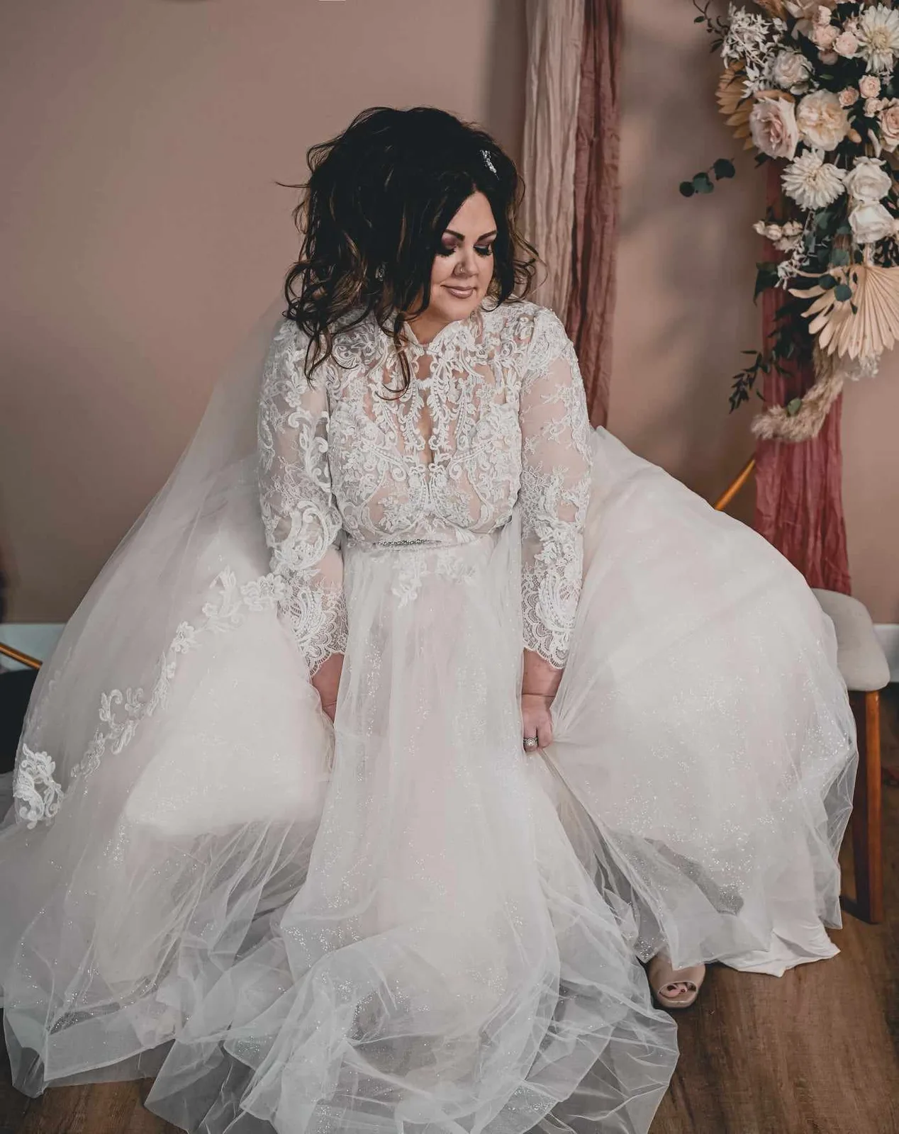 Bride seated by a window in a flowing gown